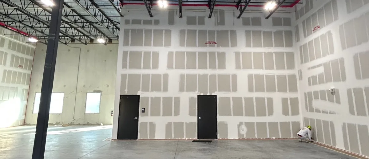 Commercial warehouse interior with taped and mudded drywall ready for priming